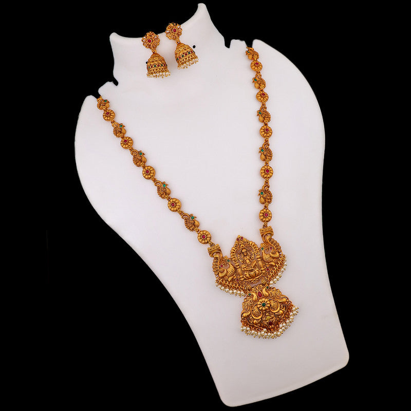 A gold necklace with intricate designs displayed on a stand, accompanied by matching earrings.