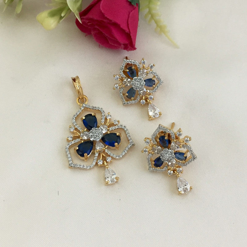 Gold and silver jewelry set with blue and white gemstones, including a pendant and matching earrings.