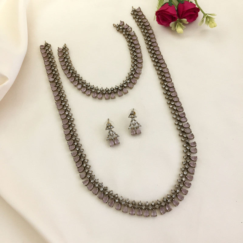 A jewelry set consisting of a necklace, a bracelet, and a pair of earrings with purple stones and intricate silver detailing.