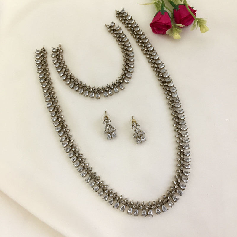 A jewelry set consisting of a necklace, a bracelet, a pair of earrings, and a smaller necklace, all adorned with teardrop-shaped stones.