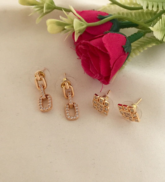 Two pairs of gold earrings, one with a rectangular link design adorned with small crystals and the other with a square grid pattern.