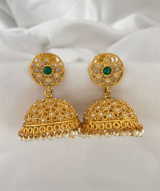 Gold jhumka earrings with intricate design, green stone, and pearl accents.